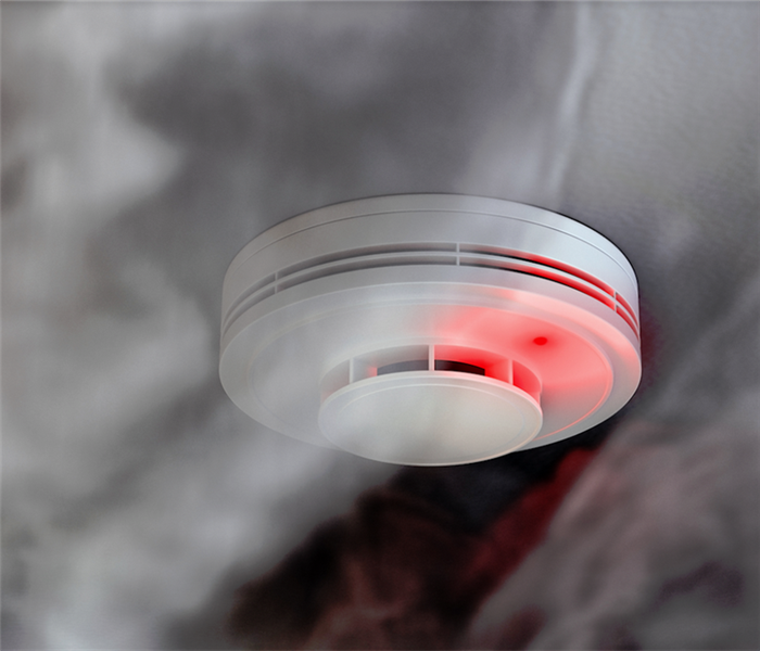 fire alarm smoke detector with red LED indicator on ceiling