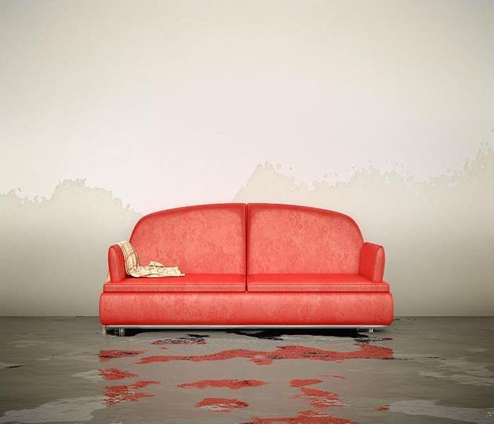 Room with red couch and water covering the floor and wicking up the walls