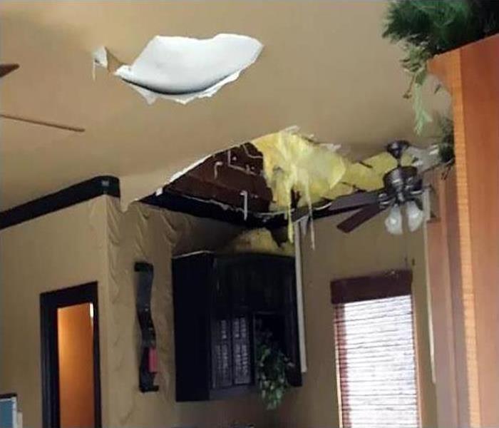 A giant hole in the ceiling of this home after a storm